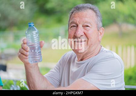 Healthy and happy, retired elderly man drinking water and staying hydrated in Toronto, Ontario Canada Stock Photo