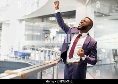 Cheerful african american young businessman celebrating success Stock Photo