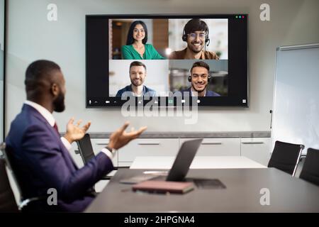 Black businessman having video conference with multiracial team Stock Photo