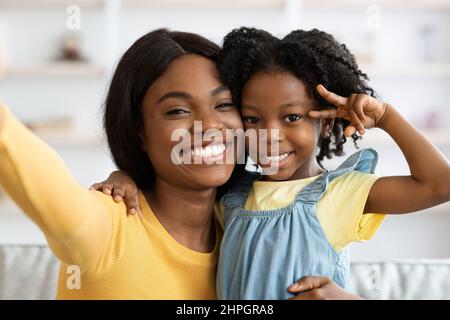 Happy Young Black Mother Taking Selfie With Little Daughter At Home, Pov Stock Photo