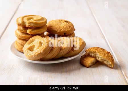 Tasty shortbread cookies with sugar on a saucer over white wooden table. Crispy butter biscuits for breakfast close-up. Danish pastry, sweet food. Stock Photo