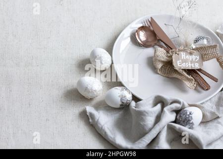 Festive Easter table setting with decor details on white table. Stock Photo
