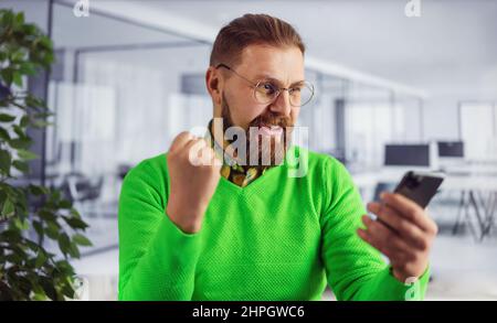 Man with smartphone at office Stock Photo