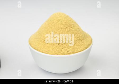 Fenugreek powder, Indian spice;arranged in a white bowl with white textured background Stock Photo