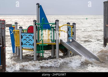 Southend on Sea, Essex, UK. 21st Feb, 2022. The strong gusting winds of Storm Franklin and high surge tide has caused the Thames Estuary to flood over the promenade and road along the seafront at Southend on Sea. The Three Shells beach playground was submerged and much rubbish was washed up Stock Photo