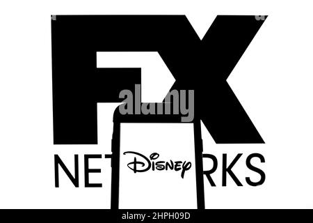 In this photo illustration, the FX Networks logo is displayed on a  smartphone screen with a Disney logo in the background Stock Photo - Alamy