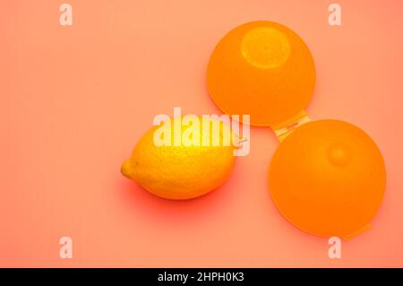 Lemon and its yellow plastic container to store the fruit. Stock Photo