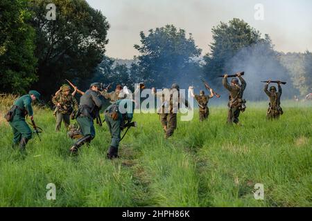 Porabka, Poland – August 07, 2021 : Reconstruction of battle from the Second World War. German soldiers with their hands raised in the air surrender t Stock Photo