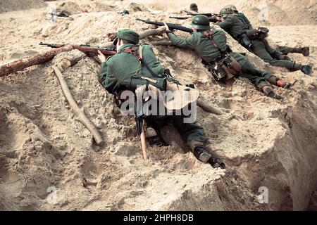 Hel, Pomerania, Poland- August 28, 2021: Reconstruction of battle from the Second World War. German soldiers with white flag in the air surrender to A Stock Photo