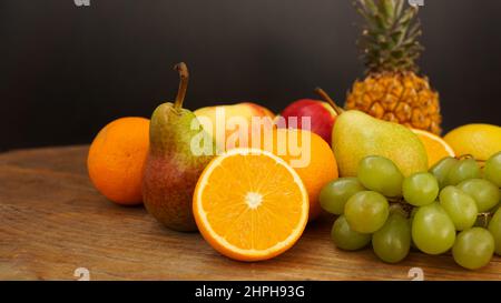 Spring or Summer concept. Many kinds of fruit lying on wooden table, can use for summer or food content background. Orange, apple, pineapple Stock Photo