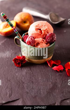 Italian style ice cream (gelato) in a cup with fruit on a slate background. Sweet and summer menu concept. Stock Photo