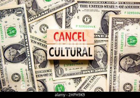 Cancel cultural symbol. Concept words Cancel cultural on wooden blocks on a beautiful background from dollar bills. Business and cancel cultural conce Stock Photo