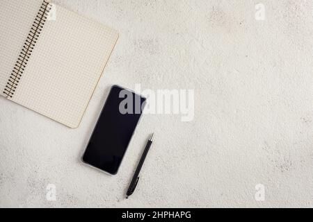 Notebook, smartphone and ballpoint pen on a white background. Stock Photo