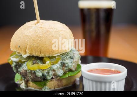 Close-up of tasty homemade hamburger on wooden table and black background Stock Photo