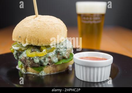 Close-up of tasty homemade hamburger on wooden table and black background Stock Photo