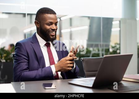 Handsome black businessman having video chat, using laptop Stock Photo