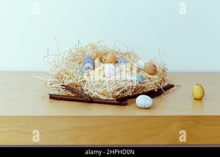 Easter background with blue, white, yellow eggs in nest. Small nest with eggs. Minimal easter composition with easter eggs. empty space, copyspace Stock Photo