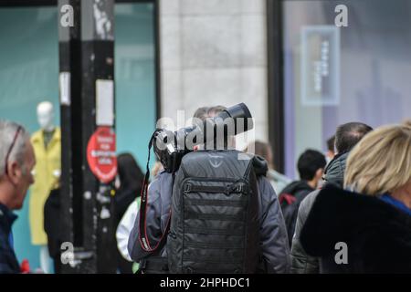 Photographer walking with a camera, Cork City. Ireland Stock Photo