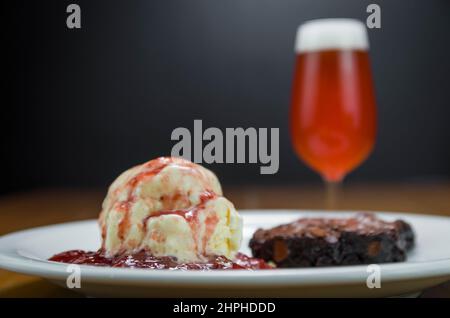 Close-up of delicious chocolade brownie dessert with cream ice cream and raspberry beer Stock Photo