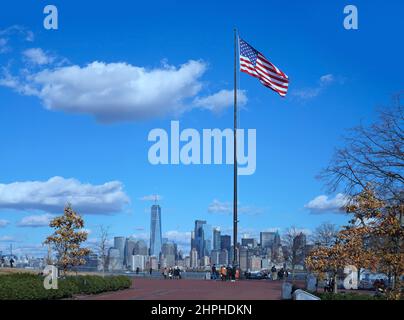 View of New York skyline with American Flag from Liberty Island Stock Photo