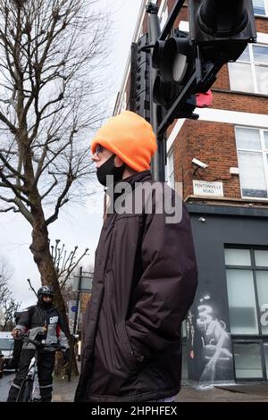Man in an orange woolly hat waits patiently to cross the road near Kings Cross, London UK Stock Photo