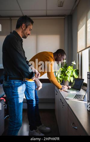 Black and caucasian men working in one office. Stock Photo