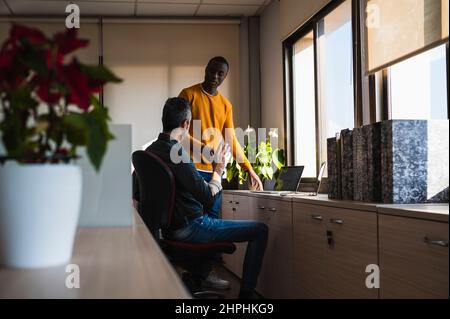 Two men of different ethnicities working in an office. Stock Photo