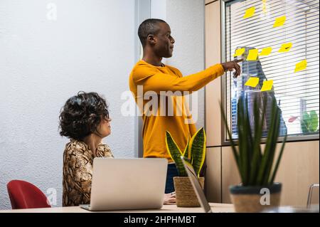 Senior woman and black young man preparing a project in an office. Stock Photo