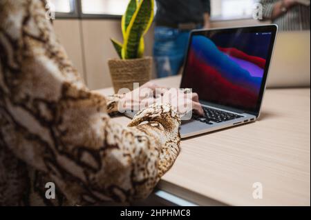 Close up of senior woman hands typing on laptop in an office. Stock Photo