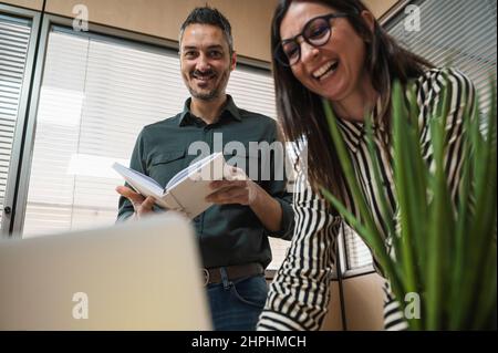 Middle age man and woman laughing while working in an office. Stock Photo