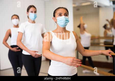 Group of multiethnic female dancers training in masks during COVID-19 pandemic Stock Photo