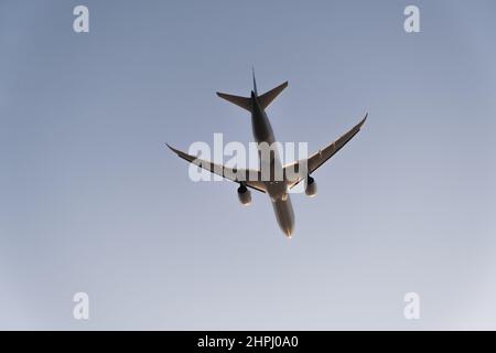 Silhouette of a twin-engine plane in the sky during sunset Stock Photo