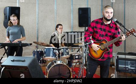 Bearded guy soloist playing guitar in studio Stock Photo