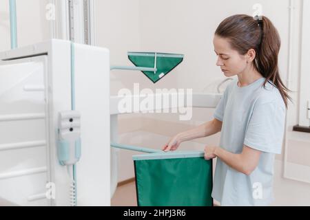 Hospital Radiology Room. Xray machine for fluorography. Doctor radiologist in gown adjusting the X-ray machine for radiography. Medical equipment Stock Photo