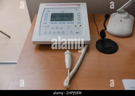 Hospital Radiology Room. Xray fluorography device remote control. Doctor radiologist in gown adjusting the X-ray machine for radiography. Medical Stock Photo