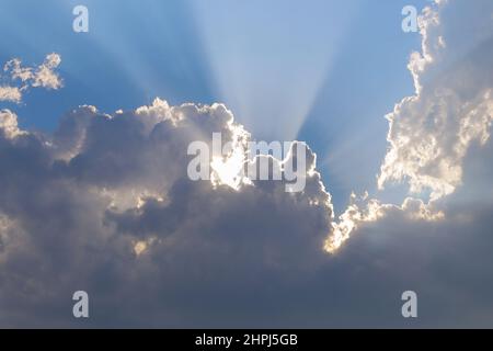Sunbeams between clouds, natural background Stock Photo