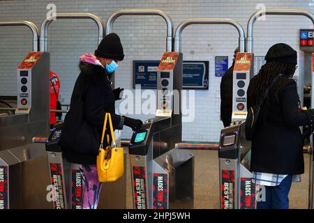 A person uses a contactless credit card to tap and go through a nyc subway turnstile. Stock Photo