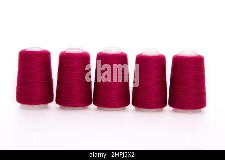 Red spool of thread isolated on white background. Skein of woolen threads. Yarn for knitting. Materials for sewing machine. Coil Stock Photo