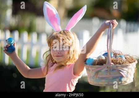 Excited child with easter basket. Easter bunny child boy with cute face. Kids hunting easter eggs. Happy easter holiday. Stock Photo