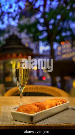 Sparkling cava wine, traditional Spanish tapas at an al fresco bar in the center of Madrid Spain and ornate old buildings in the background at sunset Stock Photo