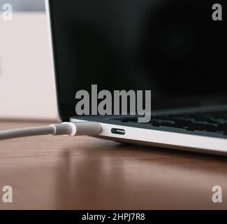 Close-up of a laptop charging through a type C usb port. Stock Photo
