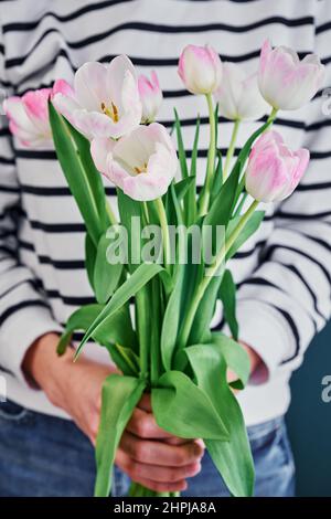 Woman holding tulip flowers bouquet in hands Stock Photo
