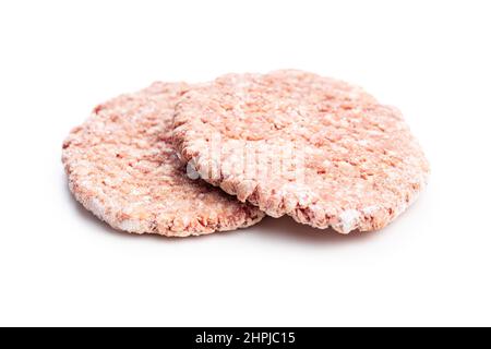 Frozen hamburger meat. Raw beef patties isolated on a white background. Stock Photo