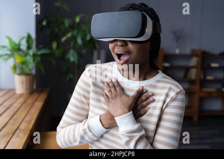 Excited African American woman with mouth widely opened experiencing virtual gaming at first time Stock Photo
