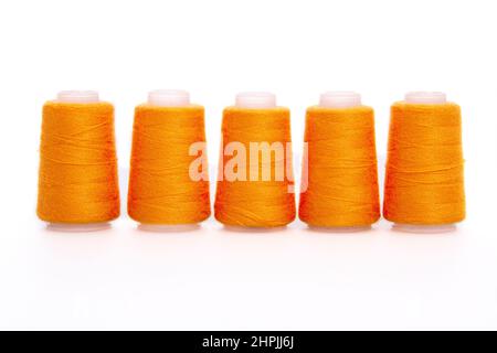 Orange spool of thread isolated on white background. Skein of woolen threads. Yarn for knitting. Materials for sewing machine. Coil Stock Photo
