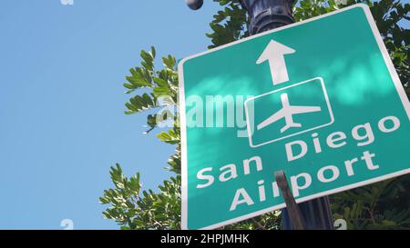 Airport green road sign with direction arrow and plane icon, San Diego city street, California USA. Tourist destination, traffic signage. Local and international traveling concept. Stock Photo