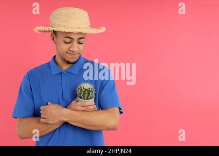 Young man with cactus on pink background Stock Photo