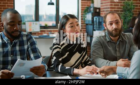 Female worker being discharged from company job by HR team, leaving office angry. Unhappy jobless woman getting fired from office work, feeling displeased and worried about employment failure. Stock Photo