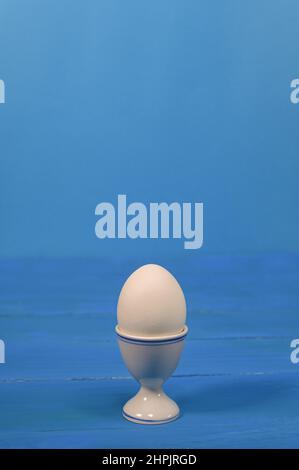 an egg in an egg cup. on a blue background. Stock Photo