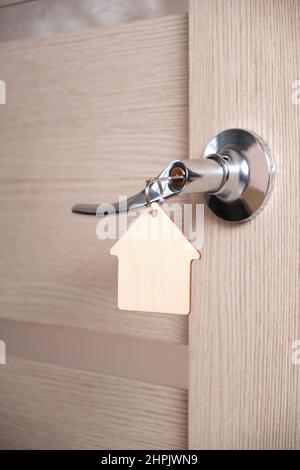 Key with keychain in form house in door lock. Stock Photo